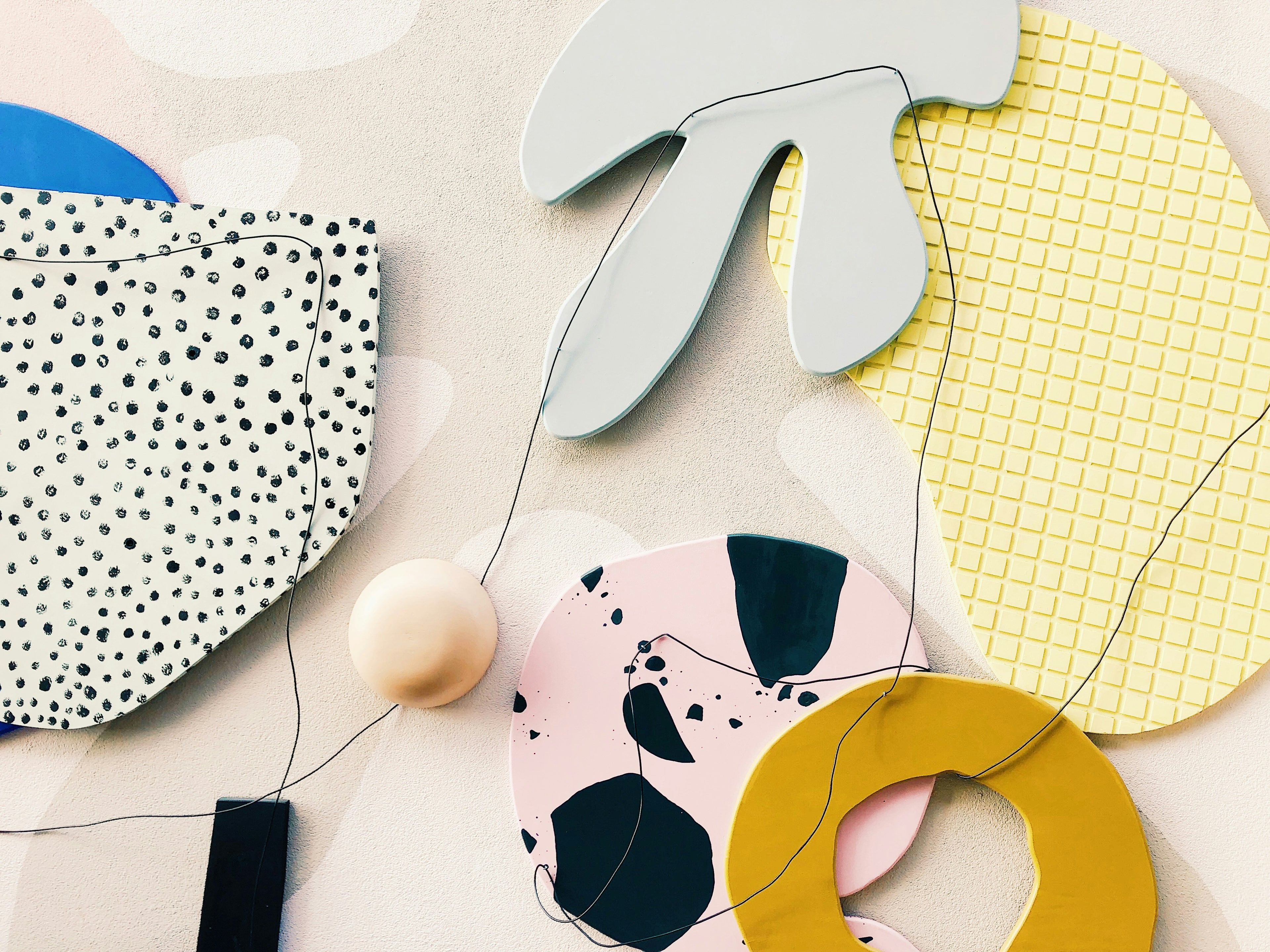 Colorful ceramic coasters with abstract patterns on a beige surface